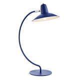 An arc shaped metal table lamp in a matte blue painted finish. The lamp is shown with a bulb just visible and is turned on in this picture.